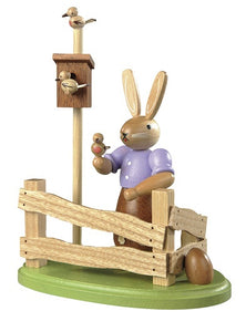 Easter bunny, female at garden fence